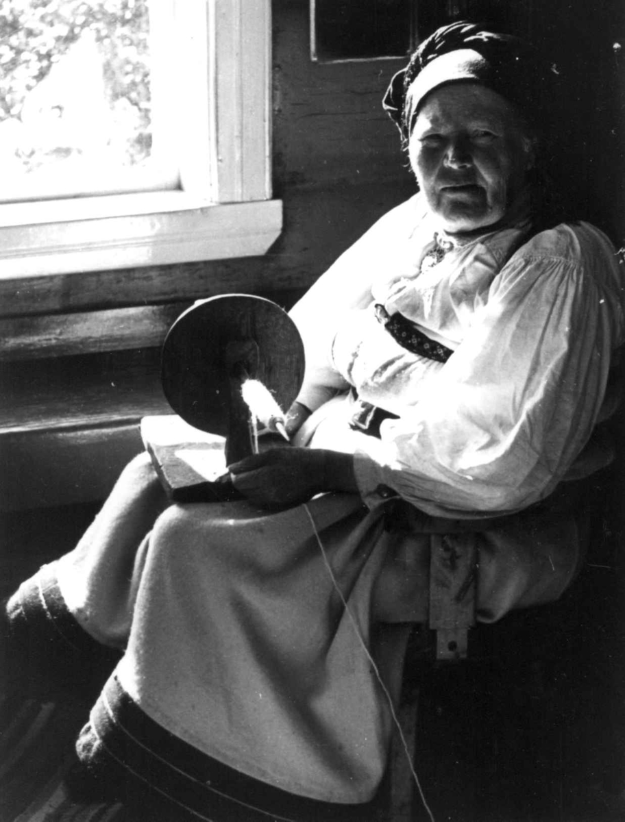Anna Grostøl, Valle 1939. Portrett av Gunnhild Viki mens hun spoler garn på trespole.