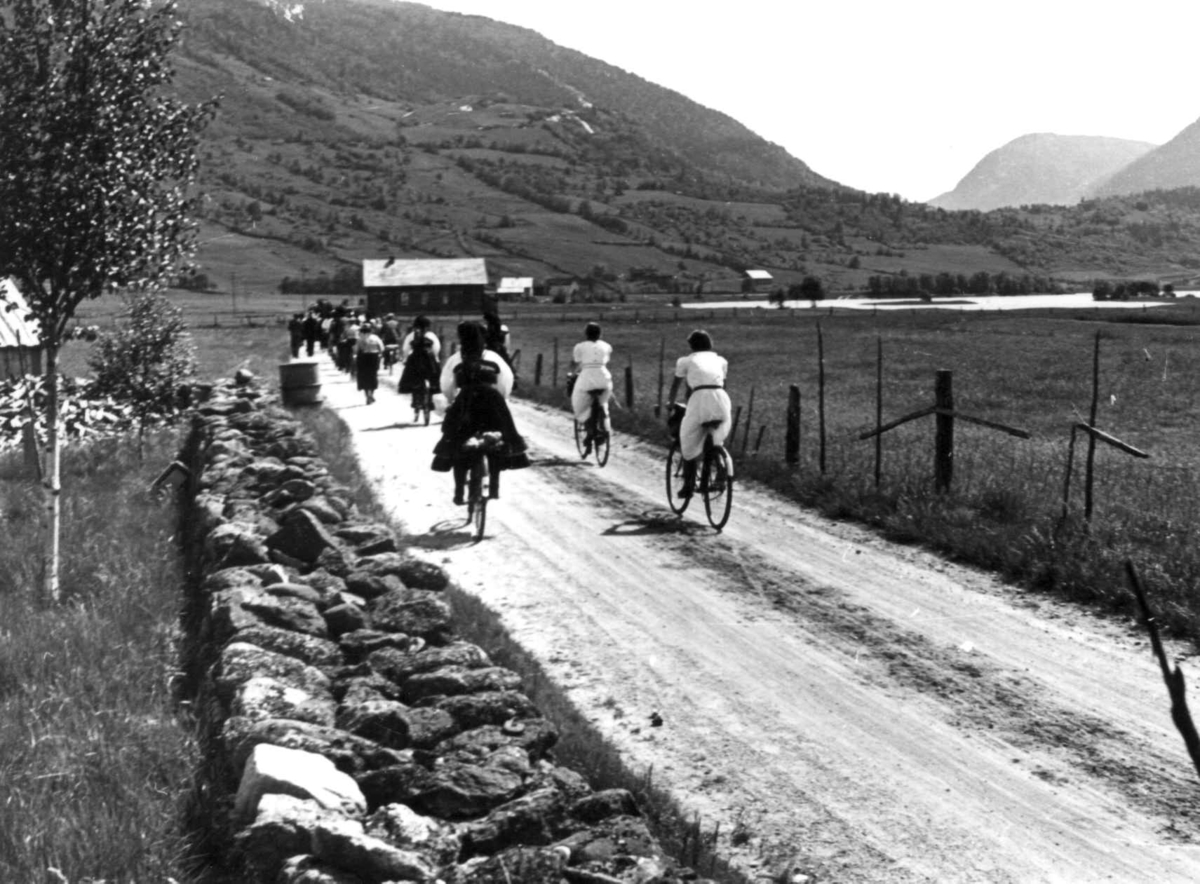 Anna Grostøl, Valle, Setesdal, Aust-Agder 1939. Bryllup. Folk spaserer og sykler på veien.