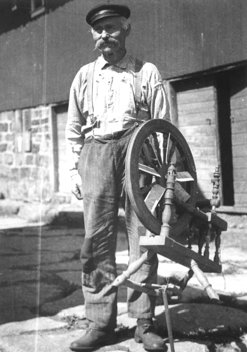 Anna Grostøl, Reinert Egegland står ved siden av en rokk. Farsund 1936.