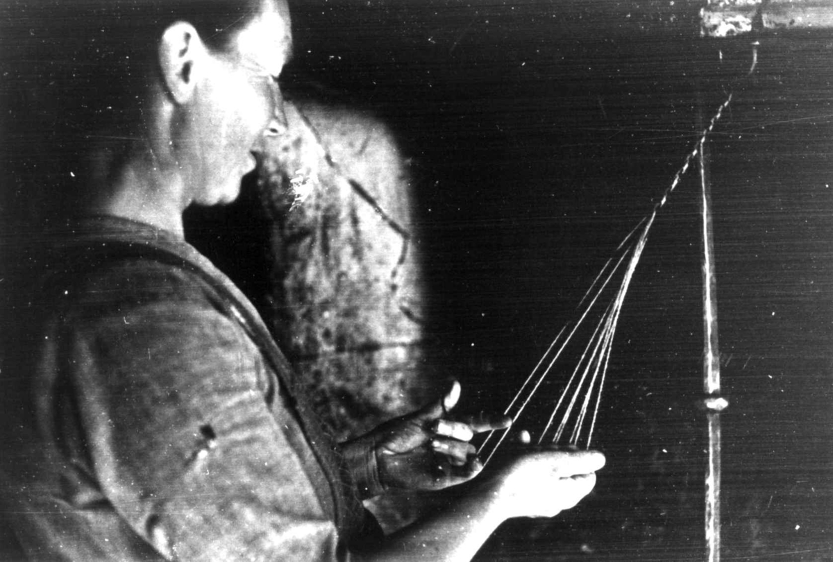 Anna Grostøl, Bråtådal, Skjåk, Oppland 1941. Ragnhild Horte bregder enkle sokkebånd av ulltråd.