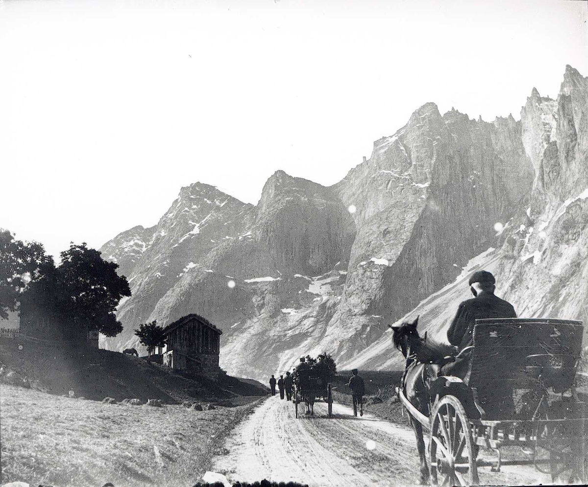 Tom Kent, Vei med hestekjerrer mellom fjell, gård på den ene siden av veien. Romsdalen ved Trollveggen.