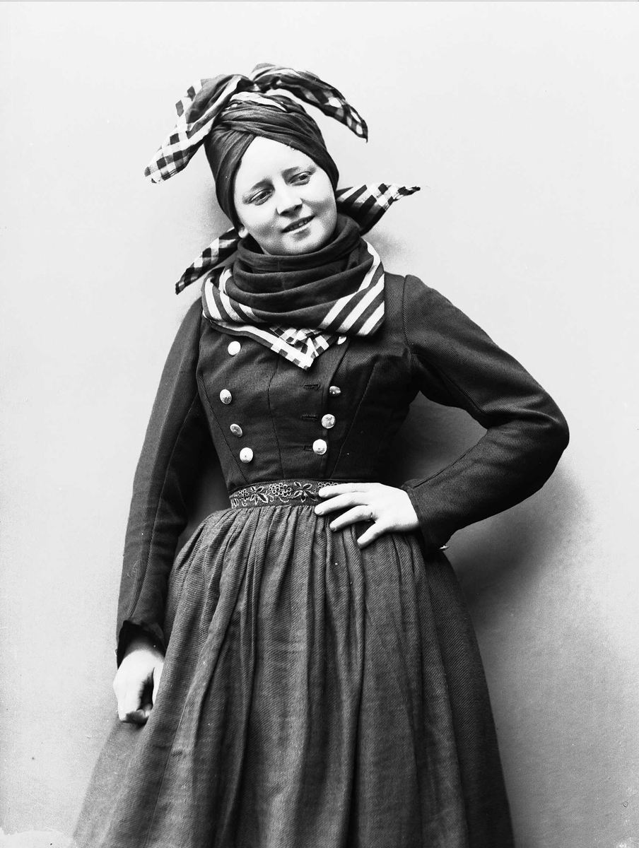 Solveig Lund, Studioportrett av kvinne i drakt, sjal og lue.