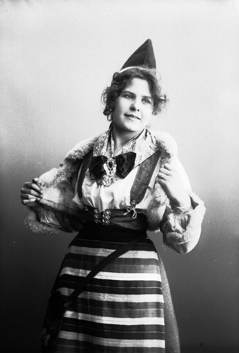 Solveig Lund, Kvinne i drakt - kort skinnjakke med pelskanter og lue.