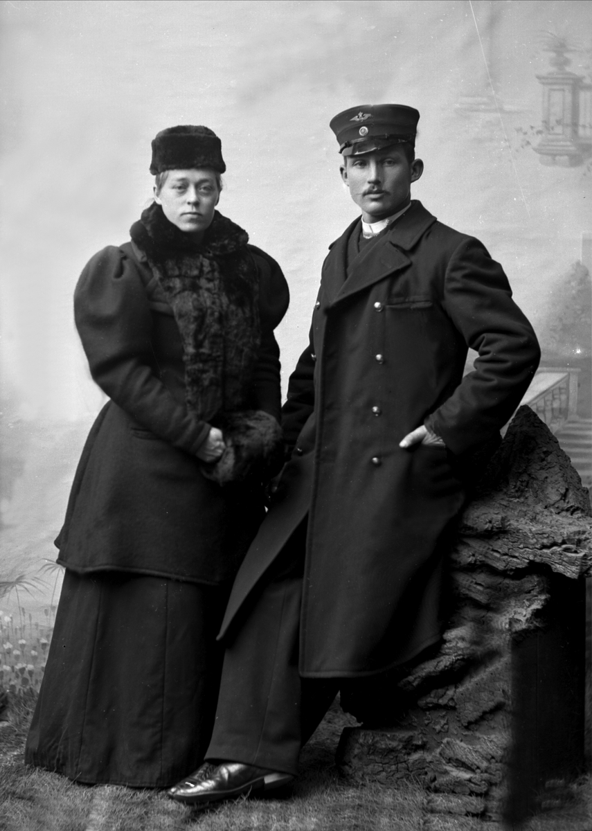Gustav Borgen, Gruppeportrett, mann og kvinne i yttertøy. Han i uniform fra Telegrafen/Televerket(?)