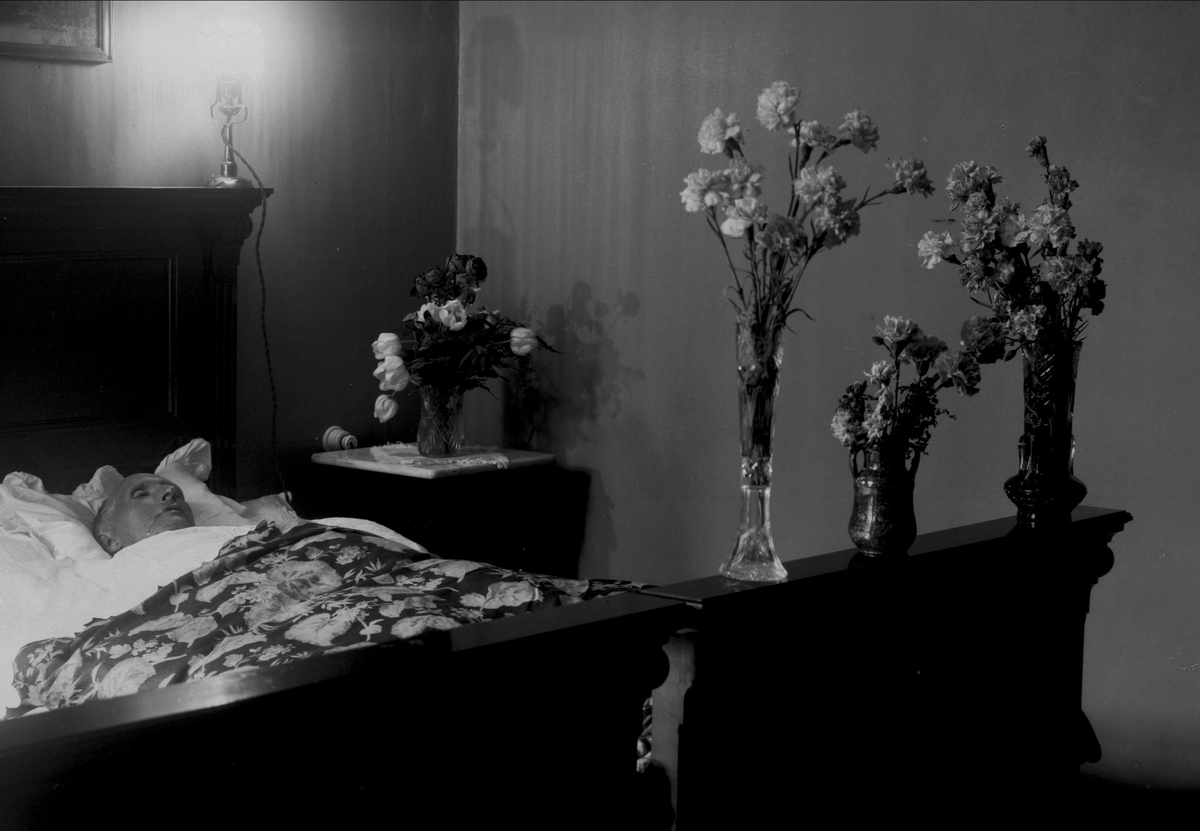 Gustav Borgen, Post mortem-fotografi. Død mann i seng. Pyntet med blomster.