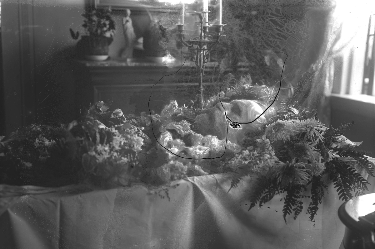Gustav Borgen, Post mortem-fotografi. Død mann i kiste pyntet med blomster.
