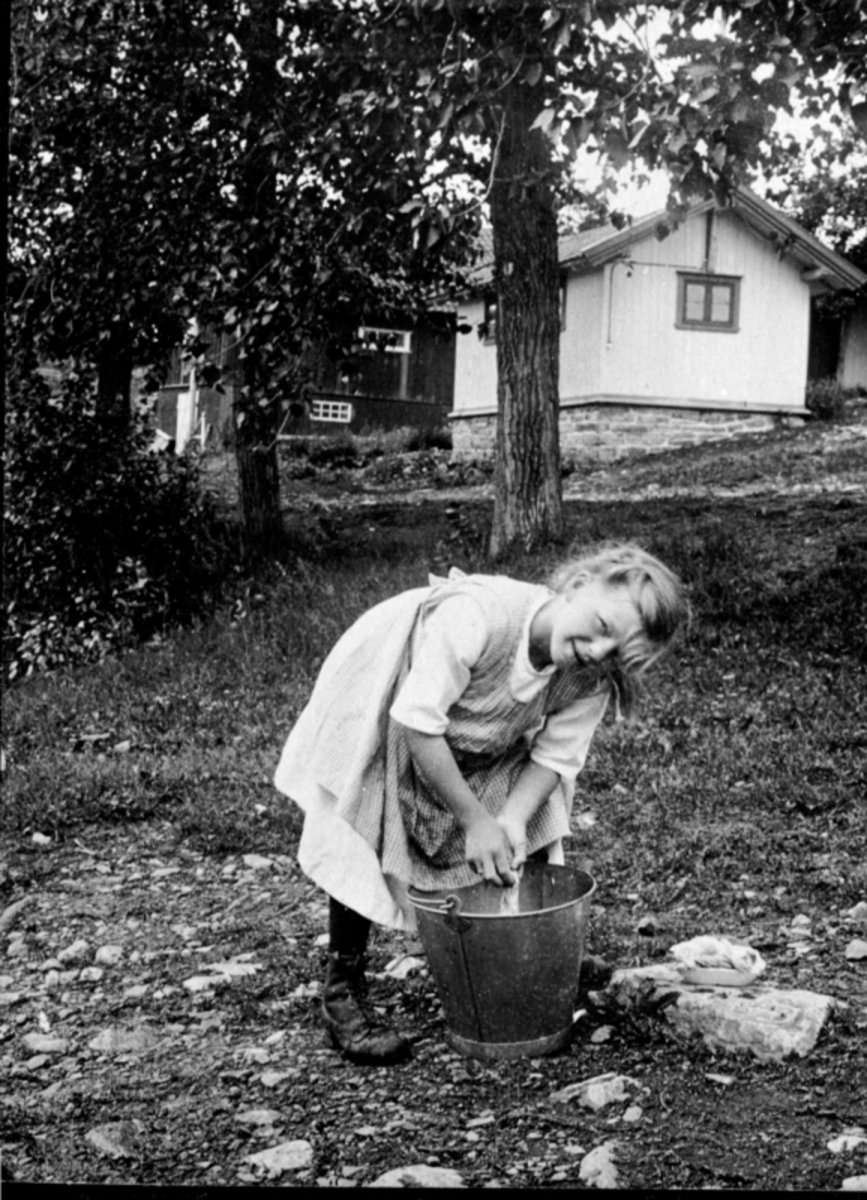 Anno Domkirkeodden, Jente vasker klær i bøtte, Heramb, Ringsaker.