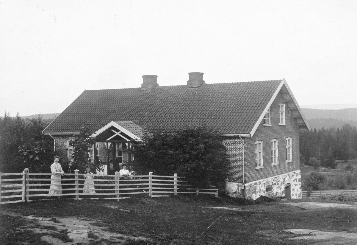 Ukjent, Helset gård, Tangen. Murbygning, teglstein, gjerde, ukjente kvinner. Ca. 1920.