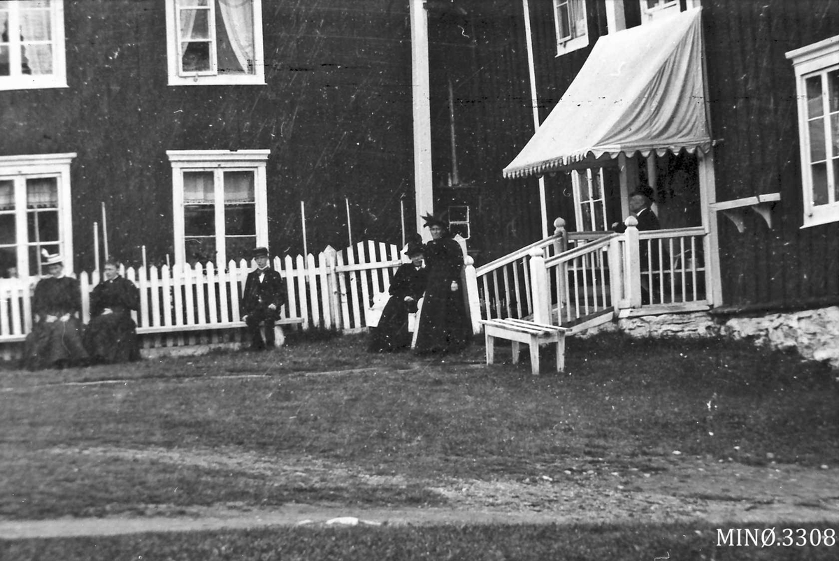 Jo Øvergaard, Utsnitt av bolighuset, inne i gårdsplassen, personer i bakgrunn
