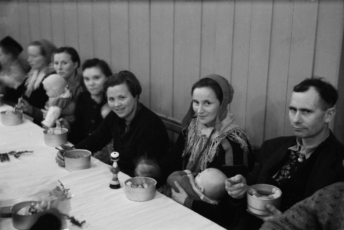 Unknown artist, Tvangsevakuerte fra Porsanger sitter til bords i Trondheim julaften 1944