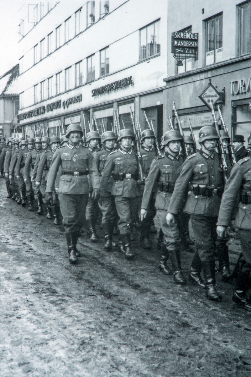 Anno Domkirkeodden, Tyske soldater marsjerer gjennom Torggata 41-43, Hamar. Okkupasjon, 2. verdenskrig