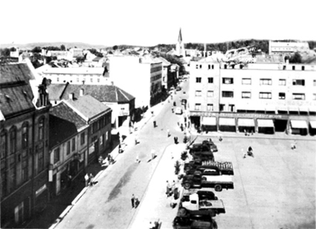 Anno Domkirkeodden, ØSTRE TORG, TORGGATA. HÅKONSGATE. PARKERTE BILER, FOLK, M. STEEN BYGGET RETT IMOT, FOLK OG BILER LANGSETTER TORGGATA, HAMAR DOMKIRKE I BAKGRUNNEN, SETT FRA ASTORIA HOTELL.