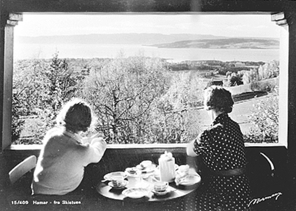 Anno Domkirkeodden, 2 DAMER SPISER FROKOST PÅ VERANDAEN OG NYDER UTSIKTEN MOT HAMAR, SKISTUA
