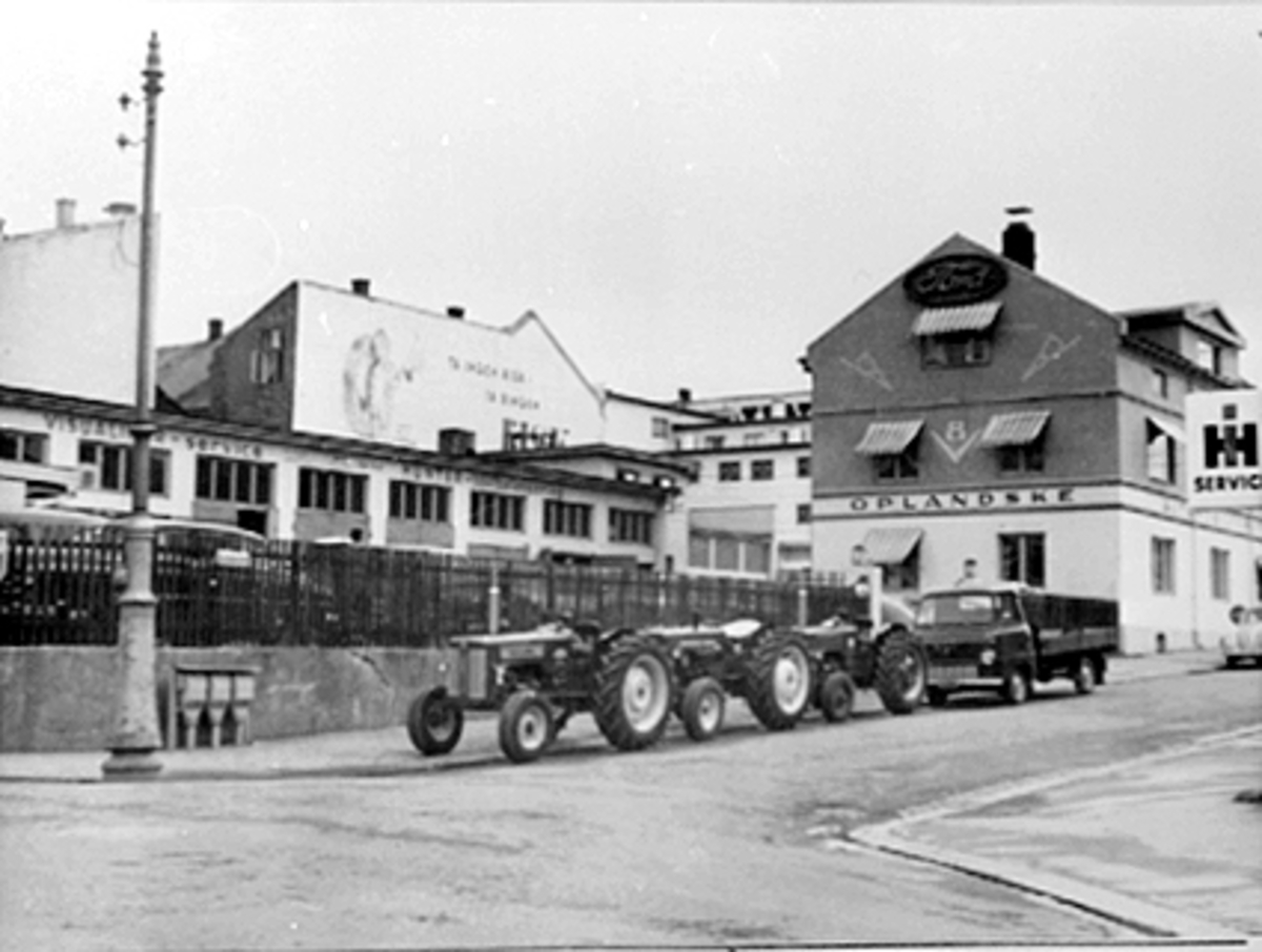 Anno Domkirkeodden, EKSTERIØR OPLANDSKE AUTOMOBILFORRETNING, ENGGATA 34, TRAKTORER, LASTEBIL, TIL VENSTRE BILREPRASJONSVERKSTEDET SOM VAR OPPRINNELIG PLATOUS VINLAGER.