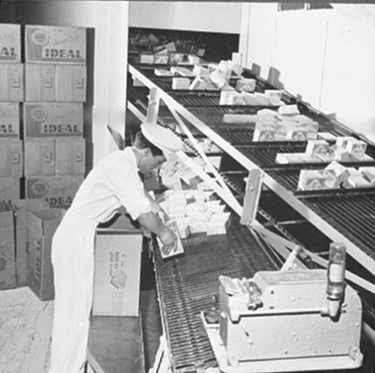 Anno Domkirkeodden, INTERIØR IDEAL FLATBRØDFABRIKK A/S, MANN VED TRANSPORTBÅND, AVKJØLING AV VOKSEDE PAKNINGER, VANGSVEGEN 51