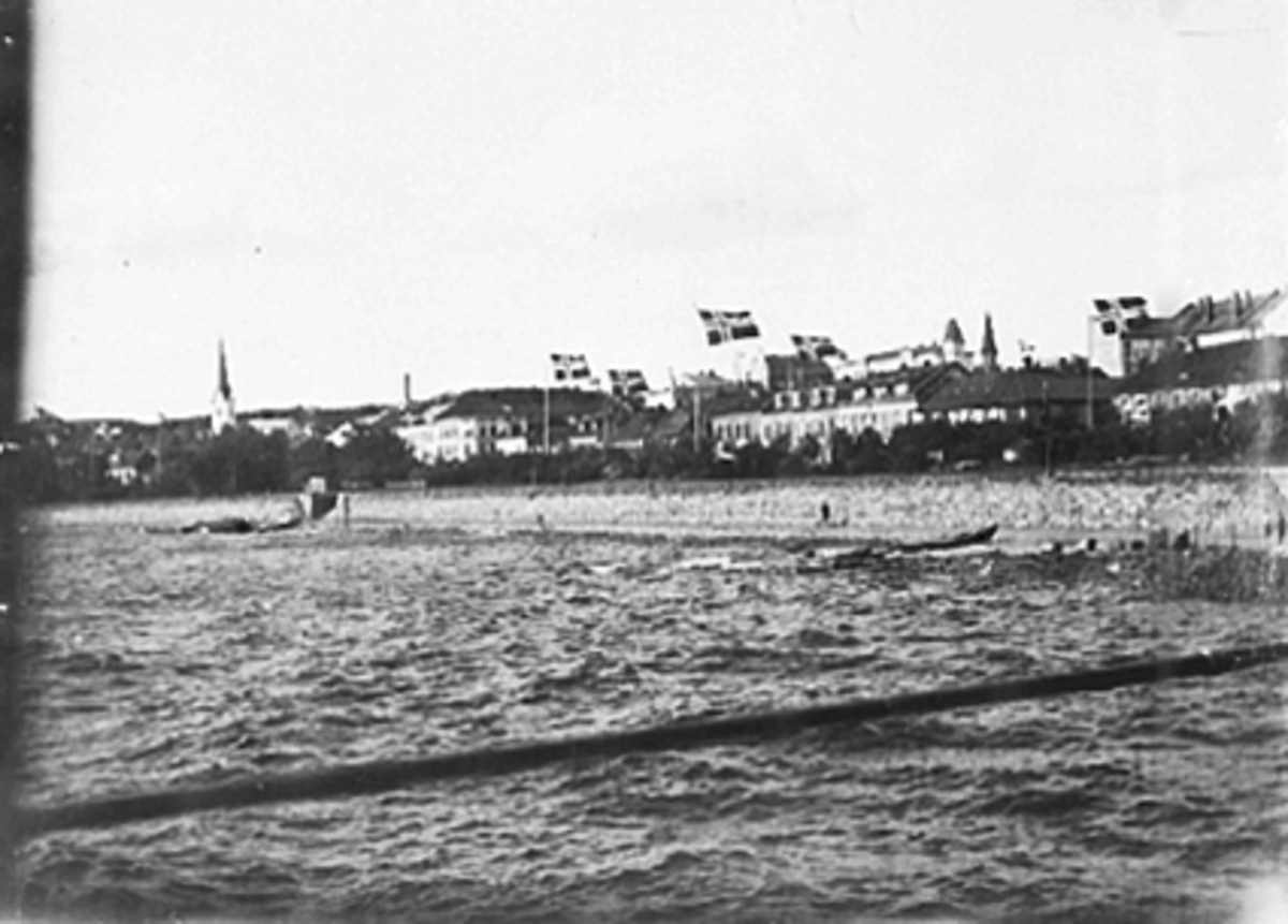 Anno Domkirkeodden, HAMARBUKTA MED VAIENDE FLAGG I ANNLEDNING FOLKEAVSTEMMINGSDAGEN 13. 08. 1905. STRANDGATA I BAKGRUNNEN