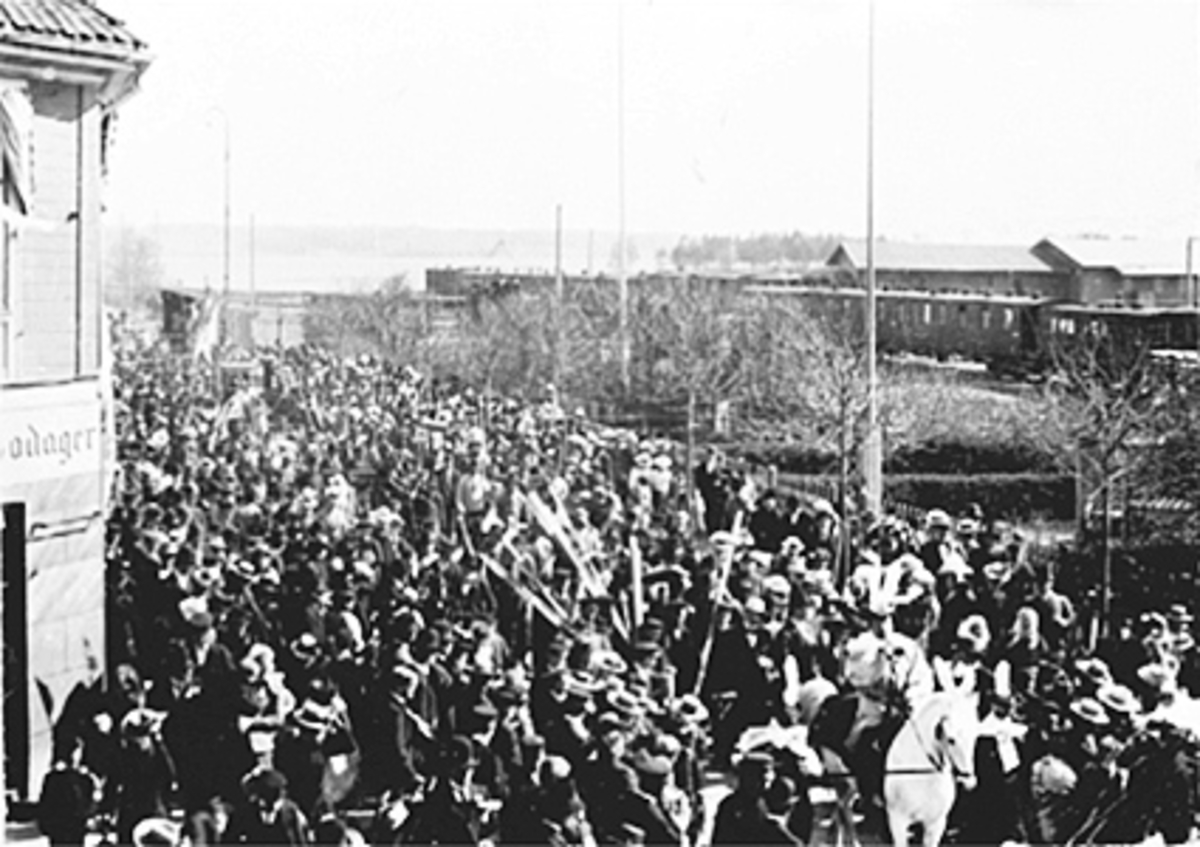 Anno Domkirkeodden, JERNBANEFORENINGENS 17 MAI TOG, MASSE MENNESKER I STRANDGATA, TOG PÅ JERNBANESKINNER I BAKGRUNNEN