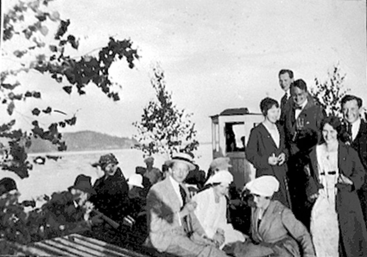 Anno Domkirkeodden, ST. HANS TUR MED BÅT PYNTET MED LØV, MYE FOLK OMBORD TIL FRYDENLUND, FURUBERGET I BAKGRUNNEN, MJØSA