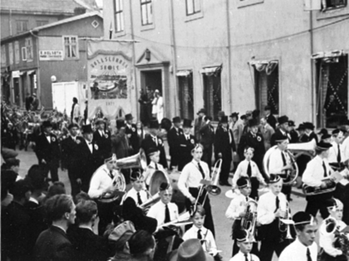 Anno Domkirkeodden, 17 MAI TOGET MED MUSIKKORPS NED GRØNNEGATA, FANE FRA ROLLSLØKKA SKOLE, LÆRERE, MYE FOLK