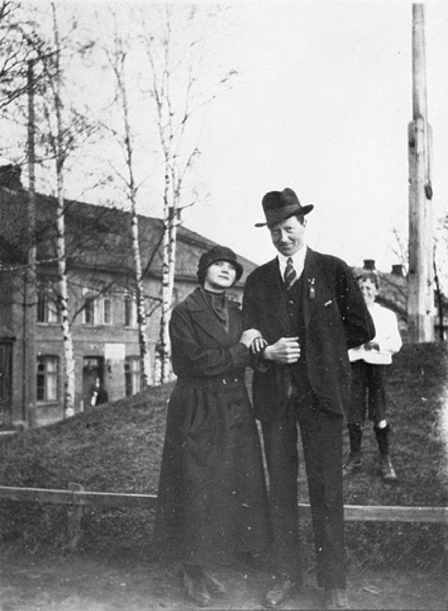 Anno Domkirkeodden, GRUPPE 2, MANN OG DAME MED HATT PÅ FLAGGSTANGTOPPEN PÅ SKOLETORGET, VESTRE TORG
