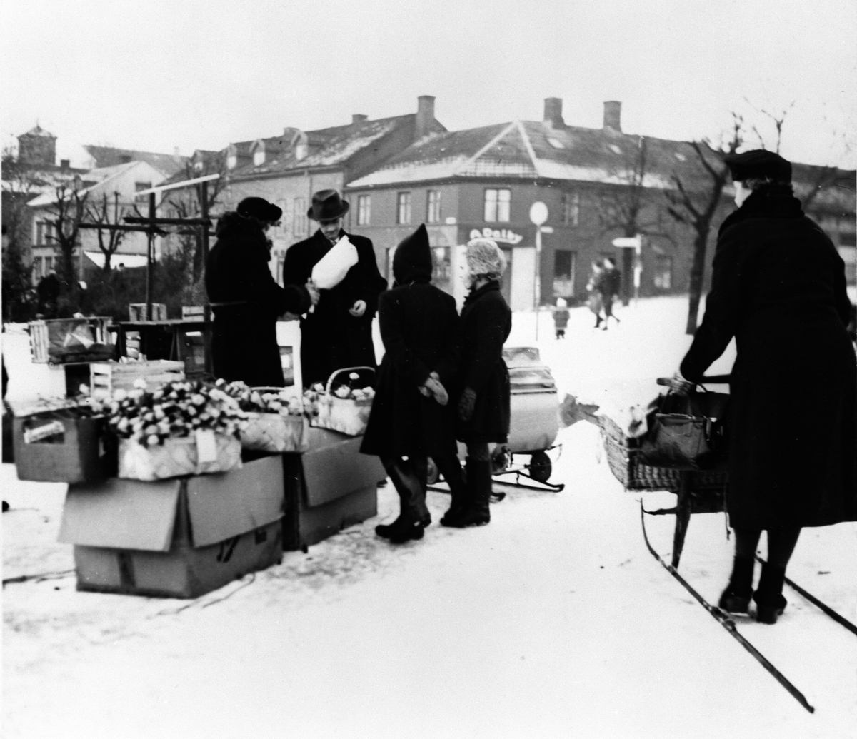 Anno Domkirkeodden, BLOMSTERSELGERSKE, STORTORGET, DAME, SPARK, BARNEVOGN M/MEIER, FOLK. Første julen etter frigjøringen, da alle skulle ha seg juletre. I forgrunnen handel med papirblomster.