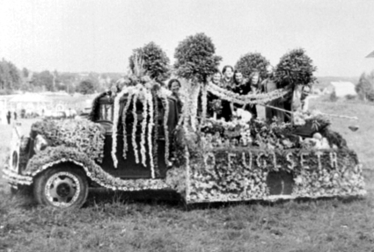 Anno Domkirkeodden, O. Fuglseths handelsgartneri, pyntet lastebil med blomster, Hamardagen 1939. Fra v: Anna Blystad Haugen, Martha Hansen, Aslaug Arnkvern, Julie Eggen, Else Berntsen, Oddvar J. Eggen, Olav Fuglseth.