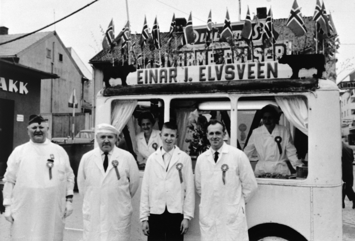 Anno Domkirkeodden, Pølsebua til Einar Elvsveen, Østre Torg, Hamar. Pyntet med norske flagg, 17.mai 1963. F.v. Einar Elvsveen, Ola Elvsveen, Steinar Bjerkli, Sverre Bjerkli. Damene i bue er fra Mathisen og Gina Windhoel.