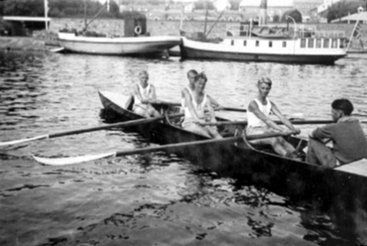 Anno Domkirkeodden, UTRIGGER (ROBÅT), FIRER MED COX, FRA VENSTRE: FINN BØHMER, LEIF AASEN, EINAR ØVERHAUG, GUSTAV HEIBERG, UKJENT, HAMAR ROKLUBB, BAK: MJØSBÅTER: TIL HØYRE HELGØY SENERE MIRA, HAMAR BRYGGE.