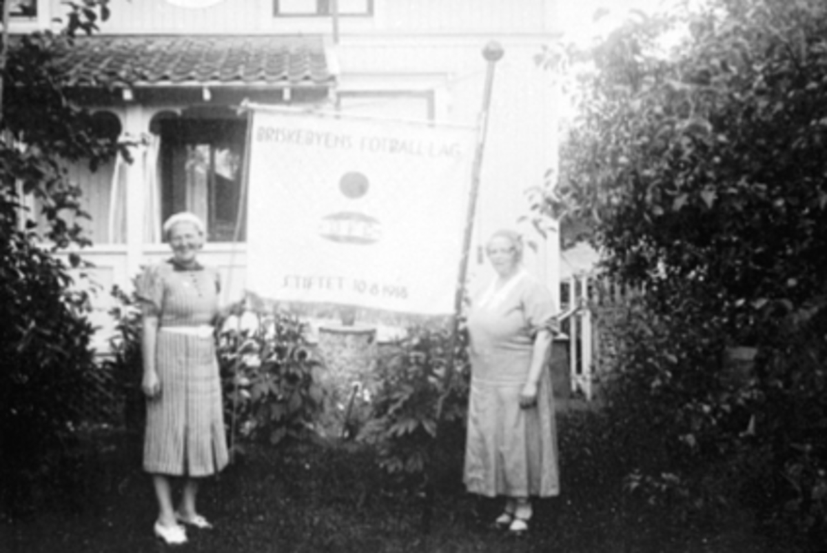 Anno Domkirkeodden, ASLAUG FINSTAD BERG, AGNES HAUGLI, NY FANE, BRISKEBY FOTBALLAG, SNERE: HAM-KAMAgnes Haugli sydde banneret, det som nå finnes i glassmonterpå Arena. Det er bare den forskjellen at klubbnavn og -merkeer endret ved at det er sydd på tøy med nye broderier.