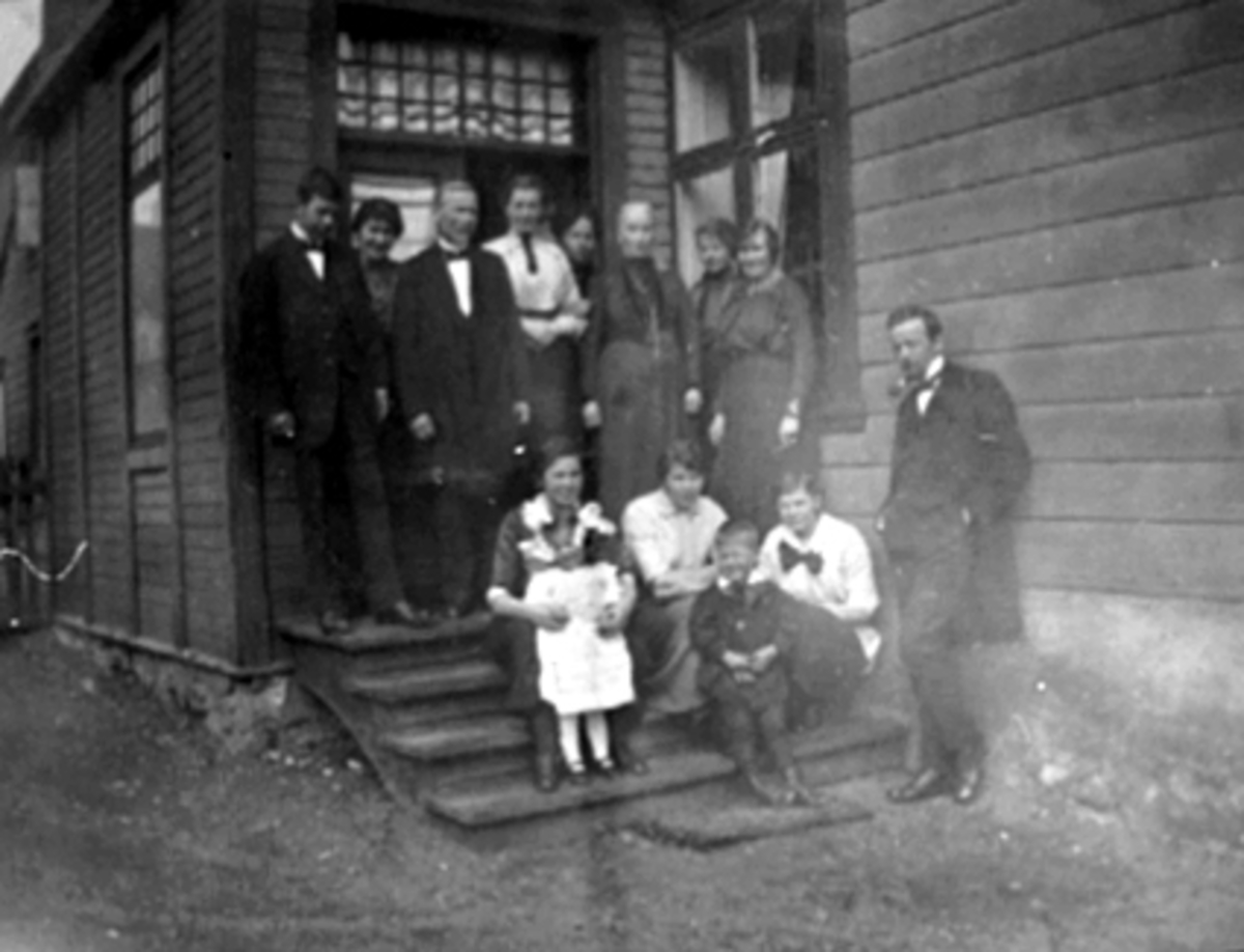 Anno Domkirkeodden, Gruppe 14, familien G. Jensen, trapp. Fra v: onkel Jørgen, en tante, bestefar G. Jensen, tante Ingrid, mor Rachel, tante Peppe (Petronelle), tante Andrea, tante Johanne, onkel Arne mot veggen, Inger Margrethe og Gubbe (Gulbrand) på fanget til Mag og Aslaug. Til h: tante Hanna.