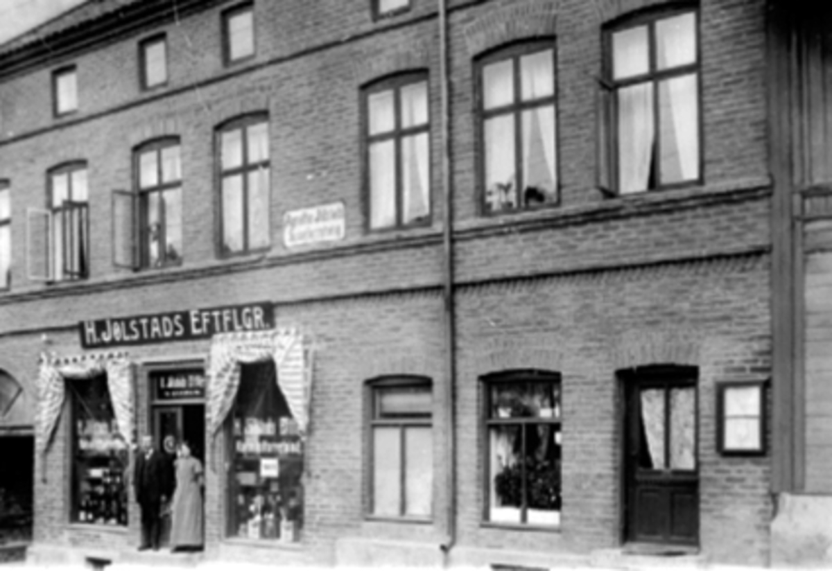 Anno Domkirkeodden, EKSTERIØR H. JØLSTADS EFTFLGR, KOLONIAL, HÅKONSGT. , SPISEFORRETNINGPostkort. Første eier var M. Gaarum. I annen etasje Agnethe Jølstads Spiseforretning.