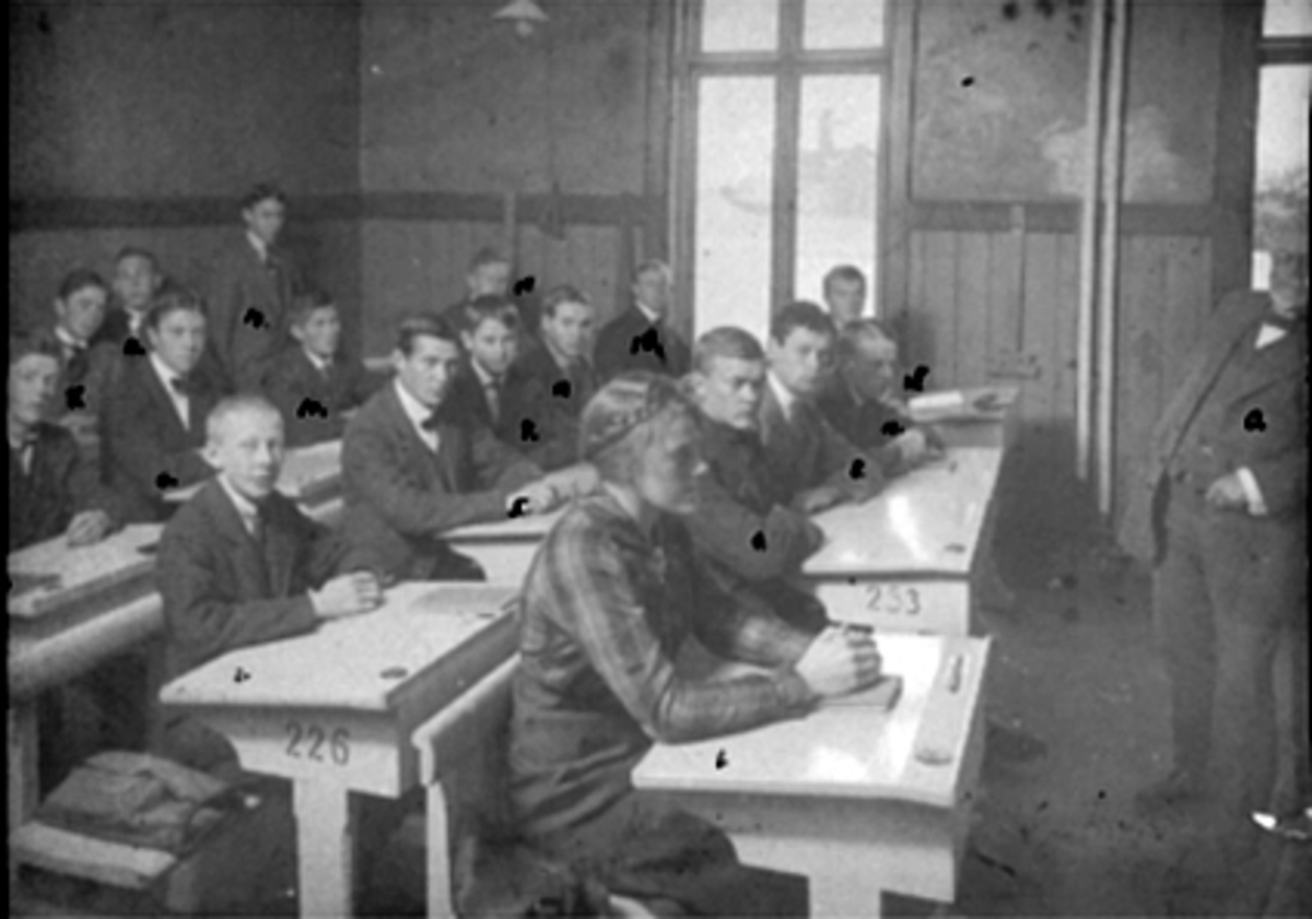 Anno Domkirkeodden, INTERIØR KLASSEROM, HAMAR KATEDRALSKOLE, 2 REAL HAMAR GYMNASIUMGRUPPE: 17 ELEVER OG LÆRER K. PETERSEN, ELEVER I REKKEFØLGE FRA DEN NÆRMESTE: BORGHILD ANDERSEN, KOLBJØRN RØHR, MICHAEL SAXLUND, ARNE BAGGERUD SMEBY, ODDMUND PENGEN, ERLING BJØRNERUD, KAARE FLADHAGEN, JOSTERUP ELSETH, NILS NØTTEESTAD, P…