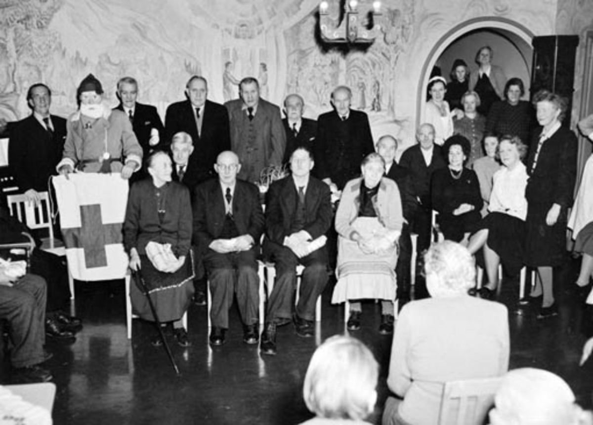 Anno Domkirkeodden, HAMAR RØDE KORS ARBEIDSGRUPPE 4, DELER UT JULEGAVER PÅ GAMLEHJEMMET. JULENISSE OG BEBOERE. HAMAR SYKEHJEM. FOTO NORMANN, HAMAR 18. 12. 1949 SE OGSÅ NEG. NR. NO 37505