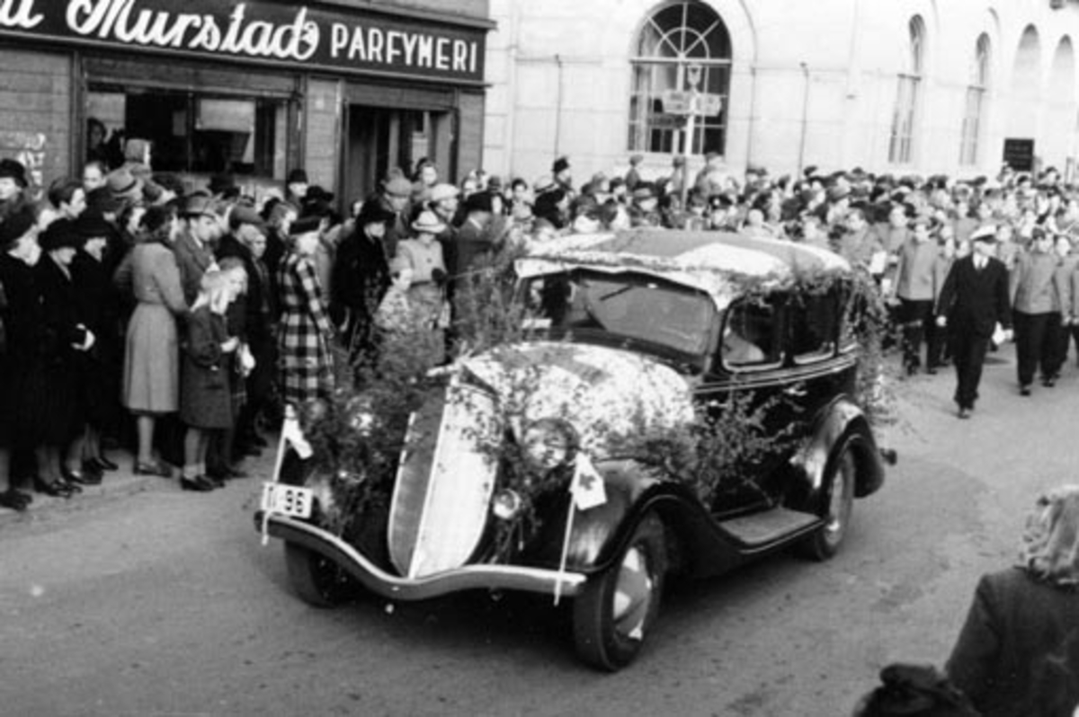 Anno Domkirkeodden, HAMAR RØDE KORS. BILKORTESJE I FORBINDELSE MED HENRY DUNANT-DAGEN 8. MAI 1946. DET DELTOK MELLOM 25-30 BILER. INNSAMLINGEN INNBRAKTE CA 6000 KRONER SOM BLE AVSATT TIL FOND TIL NY BARNEHAGE. STYRETS BIL I STRANDGATA. HUDSON 1934-35 ELLER TERRAPLANE 1935