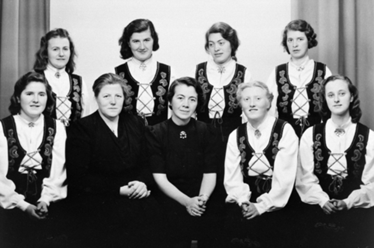 Anno Domkirkeodden, Hamar Døves Vel. Gruppe kvinner i bunad. Nr. to fv er bestyrerinne Sigrid Røssum, til høyre for henne er håndarbeidslærerinne Ingeborg Skogen. Resten er ukjente elever.