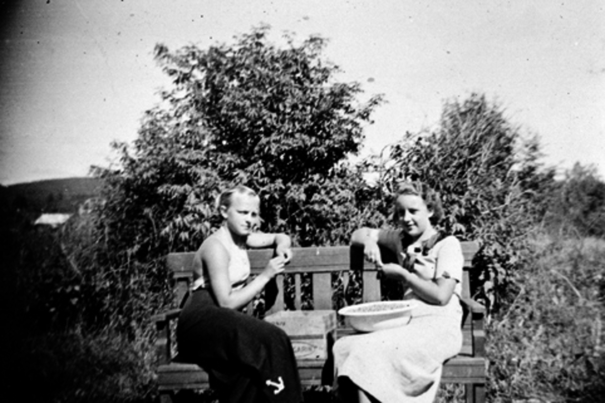 Anno Domkirkeodden, HEDMARKSMUSEET, DOMKIRKEODDEN. T. V KARIN TANGEN, F. SANDEN OG RANDI HANSEN F. MOEN, RENSER STIKKELSBÆR, SITTER PÅ EN BENK UTENFOR DEN GAMLE VAKTMESTERBOLIGEN, HAUGEN. , CA 1939-1940