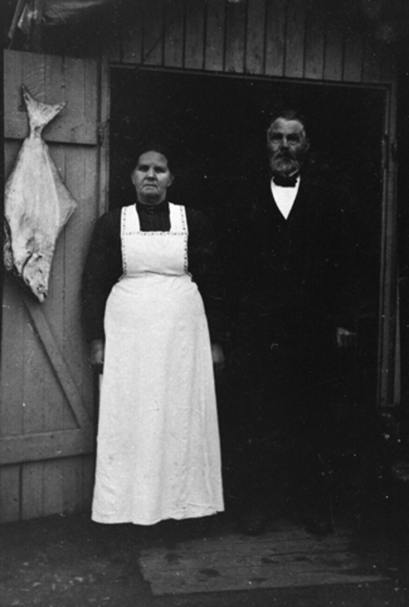 Anno Domkirkeodden, EVINE OG OLE JOHNSEN FORAN FISKEBODEN PÅ ØSTRE TORG, HAMAR. OLE JOHNSEN F. 28. 4. 1837 I HEDDAL I TELEMARK OG DØD 30. 6. 1931. EVINE F. GUDMUNDDATTER 10. 7. 1854 I ROMEDAL, DØD 29. 3. 1945. OLE JOHNSEN KOM TIL HAMAR I 1878 OG FIKK ARBERID HOS MURERMESTER FRANG OG VAR MED UNDER OPPFØRING AV HAMAR KA…