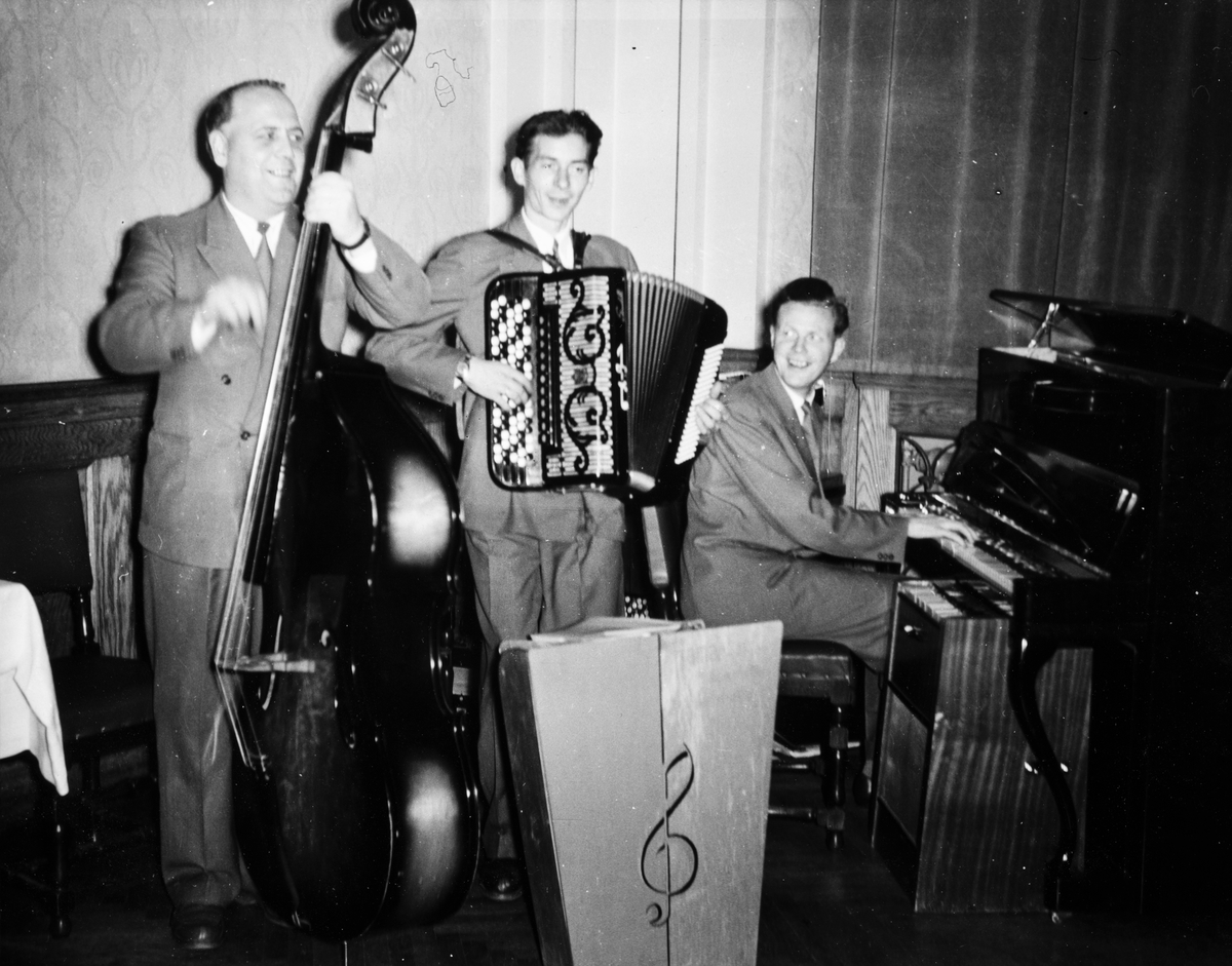 Anno Domkirkeodden, Hamar-trio`n. Wictor Nielsen piano og altsax, Arne Johansen, trekkspill, Rolf Kristiansen bass og gitar. Bildet er tatt i forbindelse med hamar Grafiske fagforenings 75-årsjubileum i Festiviteten i oktober 1957.