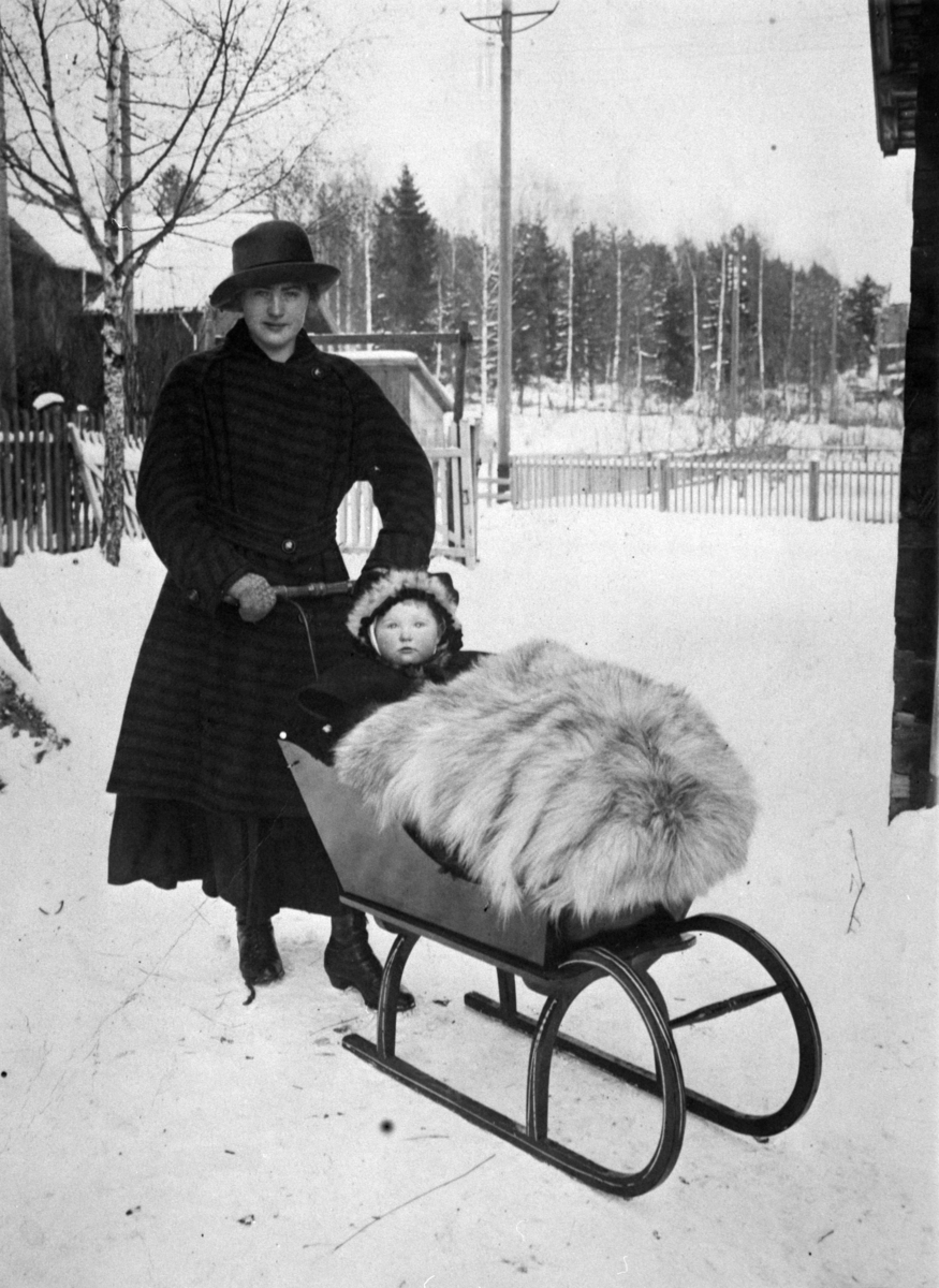 Anno Domkirkeodden, Marie Johanne (Tubbi) Dobloug født 28.11.1916, gift Tørud. Kjører barn i sluffe med skinnfell. Moelv.
