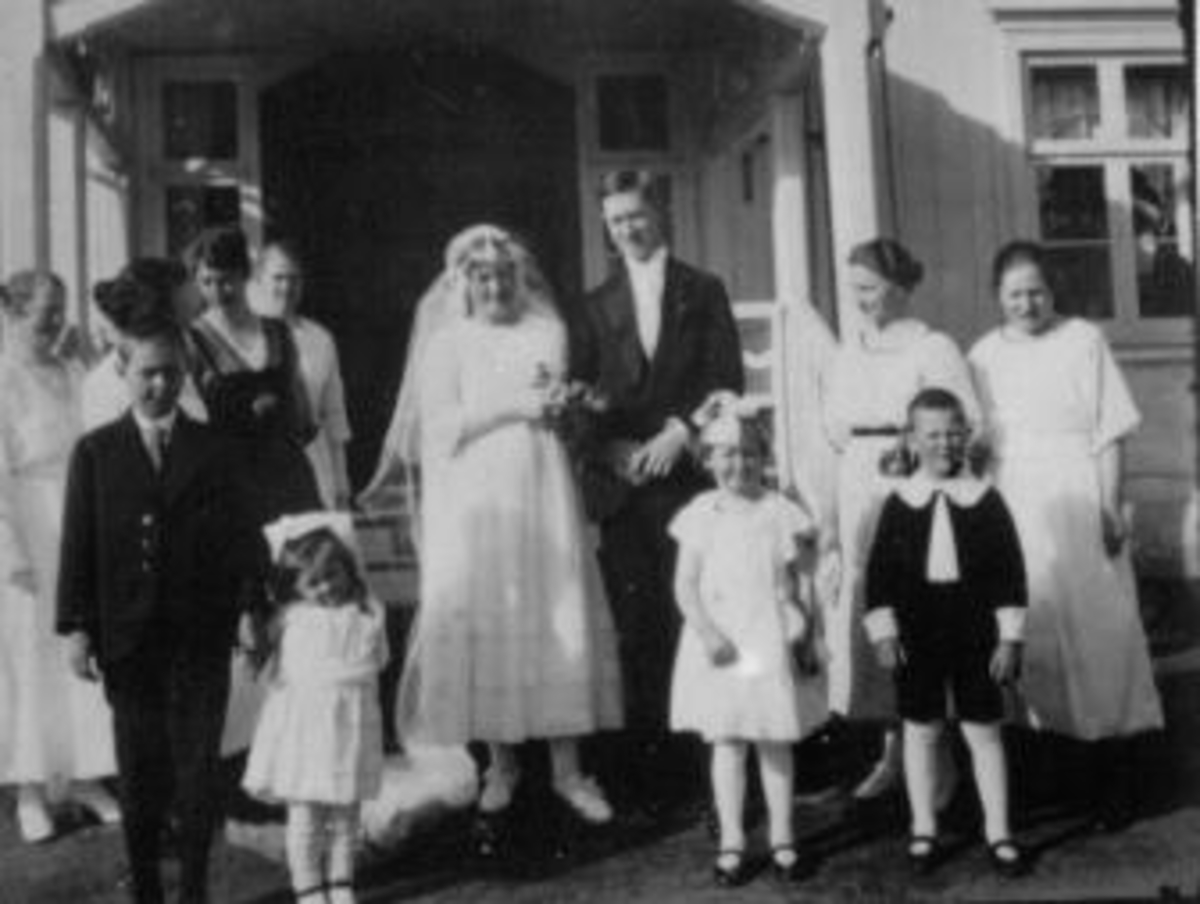 Anno Domkirkeodden, Brudepar med slekt og venner foran hus.