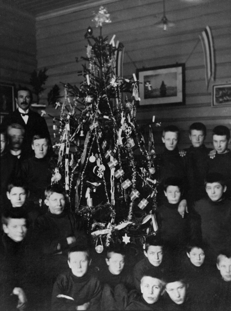 Anno Domkirkeodden, Interiør med juletre fra salen på Toftes Gave, Nedre Sund, Helgøya. Stor gruppe gutter feirer jul.