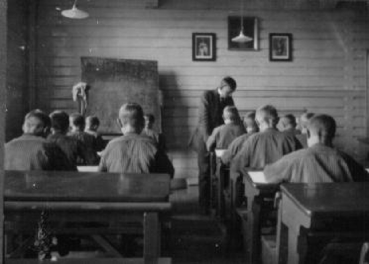 Anno Domkirkeodden, Interiør i klasserom på Toftes Gave, Nedre Sund, Helgøya. Elever ved trepulter og lærer.