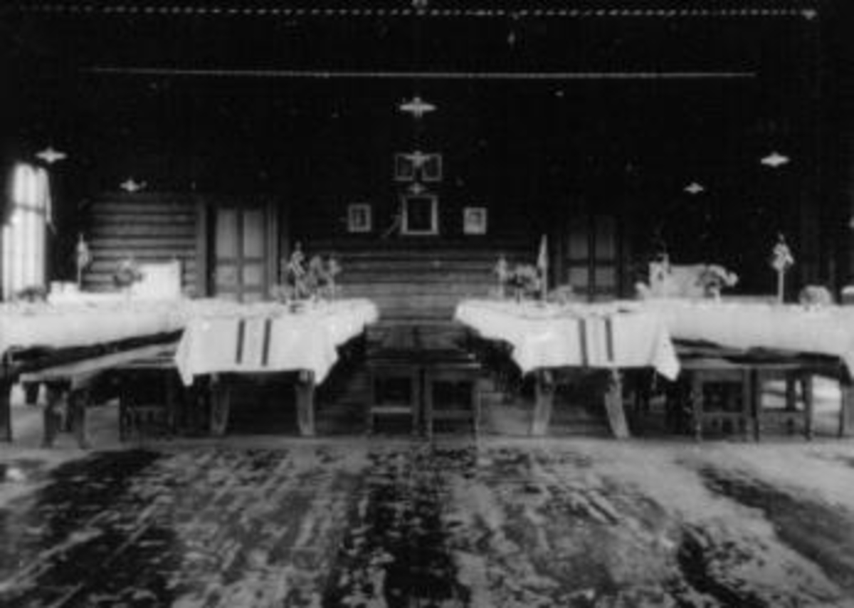 Anno Domkirkeodden, Interiør fra matsal på Toftes Gave, Nedre Sund, Helgøya. Bordene er pyntet med hvite duker og flagg.