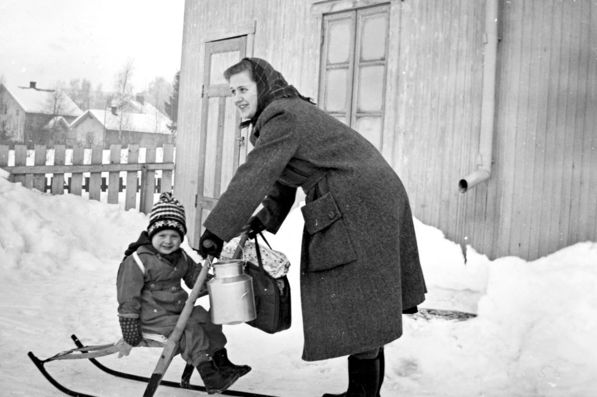 Anno Domkirkeodden, Dame med spark og lite barn med ransel. Veske og melkespann på styret. Brumunddal. Ukjente.