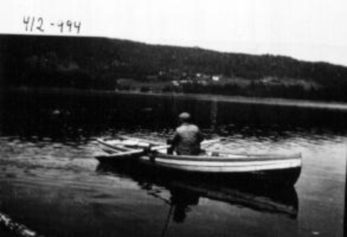 Anno Domkirkeodden, Fisketur på Mjøsa. Helge Henriksen med fiskestang i selvbygd robåt. Helgøya i bakgrunnen.