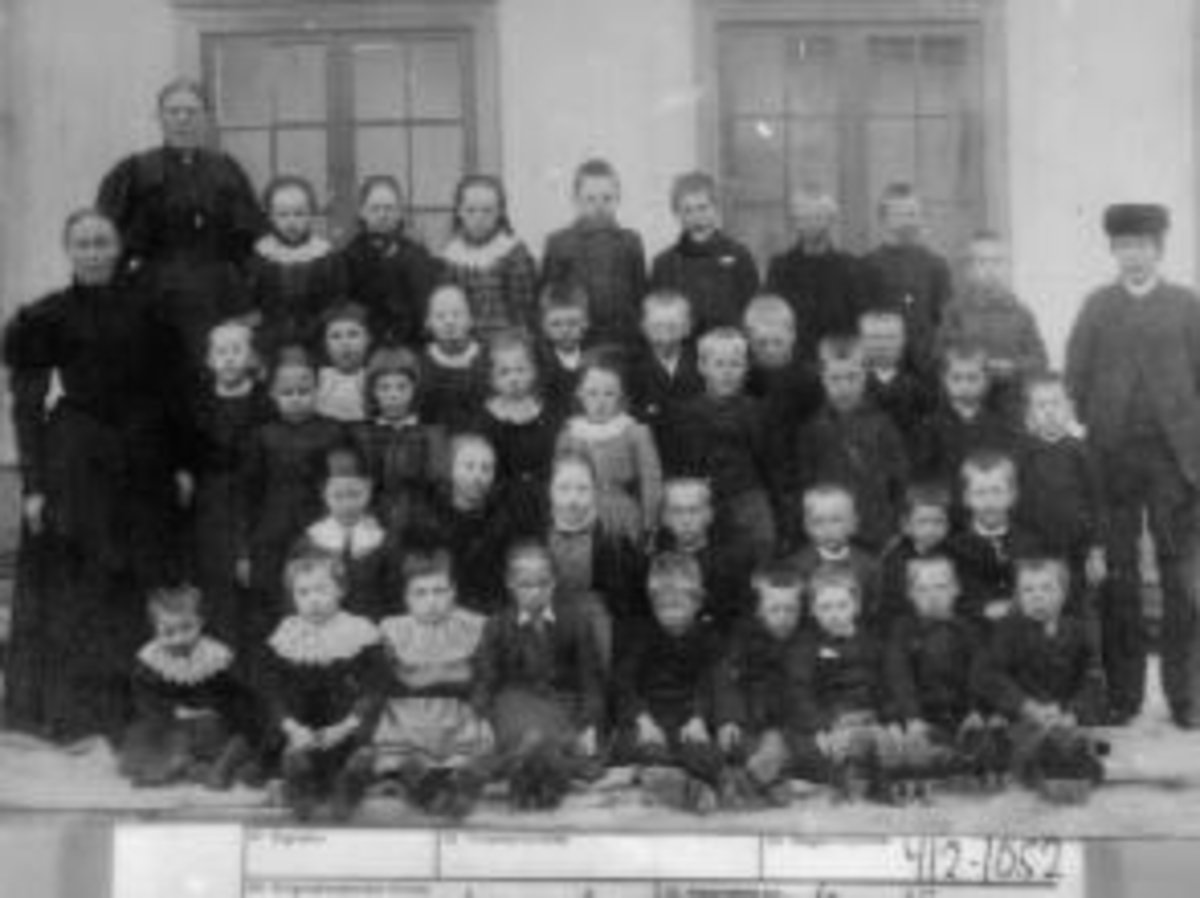 Anno Domkirkeodden, Stor gruppe skoleelever oppstillt utenfor Kirkekretsen skole, Veldre, Ringsaker. Lærer er Oline Rud.