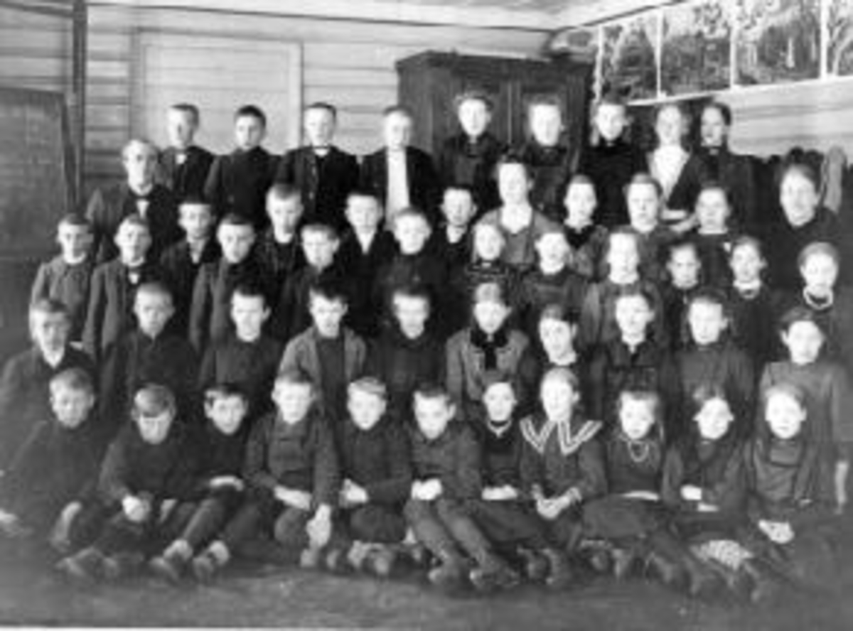 Anno Domkirkeodden, Stor gruppe skoleelever oppstillt utenfor Kirkekretsen skole, Veldre, Ringsaker. Lærere er Oline Rud og Johan Aarskog.