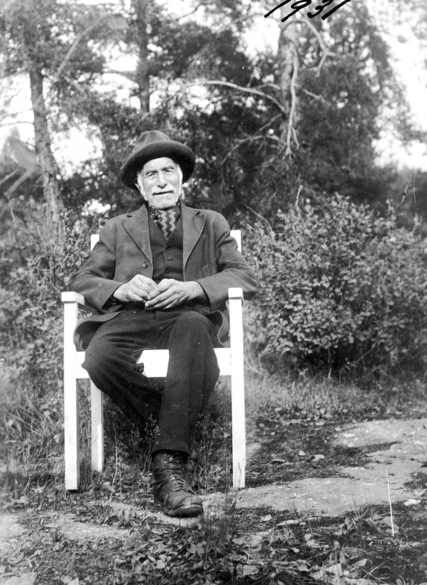 Anno Domkirkeodden, Portrett av eldre mann i stol, utendørs. Mathias Tokstad, Ringsaker.