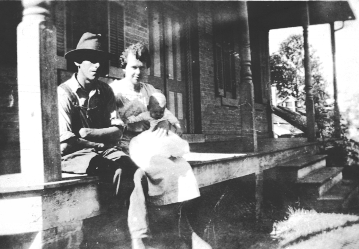 Anno Domkirkeodden, 3 personer på trapp foran hus. Eilert Linnerud f. 1896 og Bergljot Linnerud med sønnen Erlig f.1920 på fanget. De reiste til Wisconsin i USA i 1918.