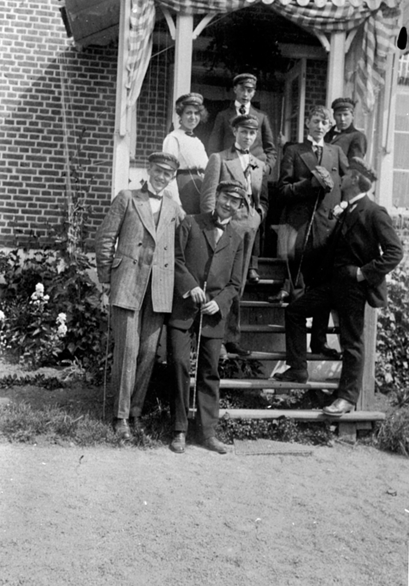 Anno Domkirkeodden, Stor gruppe rødruss på fest hos doktor Karl Løken på Granerud gård, Brumunddal. Fra venstre er Ester Dæhlin, Hans Normann, Ivar Haug, Trygve Fremstad f.1894, Henrik Hornemann. Foran er Karl Løken f.1894, Øyvind Stav f.1893, Ivar Vefring f.1896.